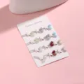 Dettaglio in primo piano di spille per scialle in cristallo multicolore su cartesio espositivo. - A-1