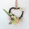 Künstlicher herzförmiger Blumenkranz mit rosa Rosen und Rattan, ideal für Wanddeko. - Hellrosa