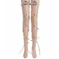 Detailed view of gold leg straps featuring delicate bee appliques and leaf charms for costume. - Gold + Bee