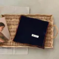 Vue détaillée d'un foulard rétro en coton et lin de couleur unie marine avec bordure marron. - Bleu Marine