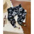Detail view of a retro floral cotton linen triangular scarf with beaded strap accents. - Black and White Floral
