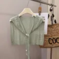 Close-up detail view of light green hollow-out knitted tie-front small shawl and capelet top. - Matcha Green