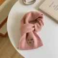 Detailed view of a cozy pink knit wool blend winter scarf featuring cute embroidered pony motif. - 7# Peach Pink