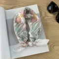 Detail shot of a vintage pastoral style floral print cotton square scarf resting on a book. - Picture #9