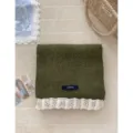Cozy dark green knitted winter scarf with white lace ruffle trim and brand label flat lay. - Army Green