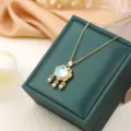 Elegante collar con colgante de candado dorado, piedra azul y cadena fina para mujer. - Dorado