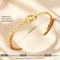 Goldener Edelstahl Liebesknoten offener Armreif, wasserdichter hypoallergener Schmuck. - Goldene doppellagige Knoten