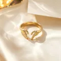 Impresionante anillo abierto dorado con diseño de manos enlazadas, elegante joya de acero. - Anillo / Dorado