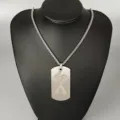 Stainless steel letter X pendant necklace detail shot, showcasing cutout design and metal chain. - Letter X
