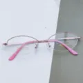 Detailed close-up shot of rose gold semi-rimless oval eyeglasses frame with pink temples. - Pink / Plain