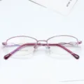 Detailed view of pink semi-rimless eyeglasses frame, featuring exquisite diamond-set temple. - Purple