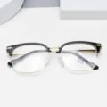 Close-up detail of stylish half-frame glasses with black and gold design, clear lenses. - Black & Gold