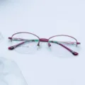 Close-up of women semi-rimless metal eyeglass frame with stylish cutout temples and clear lens specs. - Purple
