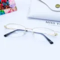 Close-up detail of women's semi-rimless metal optical glasses frame with flexible temple. - Gold