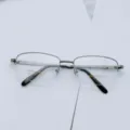 Detailed close-up shot showing the metal half-frame glasses structure and details. - Gun Grey
