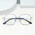 Close-up detail of the vintage polygonal titanium eyeglass frame, showing clear lens specifications. - Black & Gold