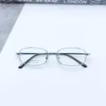 Detailed view of men's metal full-frame optical glasses with titanium temples and square shape. - Silver White