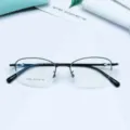Detailed view of the metal semi-rimless oval eyeglass frame, lightweight and durable. - Bright Black