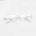 Detailed shot of semi-rimless oval glasses frame with pink temples and titanium material. - Pink Gold