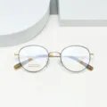 Retro round metal eyeglasses frame detail shot, lightweight titanium optical glasses for daily wear. - Black & Gold