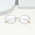 Detail view of round beta-titanium glasses frame with clear demo lens, gold thin rim. - Black Rose