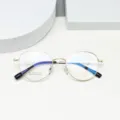 Round metal eyeglasses frame detail featuring beta titanium material and clear demonstration lenses. - Bright Gold