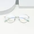 Detail view of minimalist round beta-titanium eyeglasses frame in silver, high quality. - Silver White