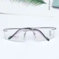Detail shot of lightweight rimless optical glasses frames with square demo lenses and metal temples. - Gunmetal Gray