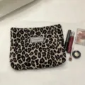 Close-up detail of the stylish leopard print cosmetic pouch, showing the retro woven label. - Dark Leopard