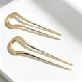 Closeup detail view of minimal gold U-shaped hair pins, elegant smooth metal finish for styling. - 2 Pieces/Pack / Gold