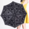 Élégant parapluie pliant noir avec dentelle brodée et protection UV pour le soleil et la pluie. - Noir