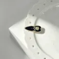 Close-up detail of a vintage French black and gold rose enamel side hair clip, elegant accessory. - Black