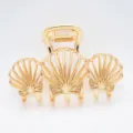 Detailed view of golden zinc alloy triple shell hair claw clip for elegant styling. - Triple Shell Shape