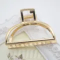 Detail view of a minimalist zinc alloy hair claw clip, large gold geometric hair accessory. - Raised-Edge Geometric Shape