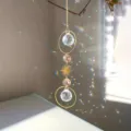 Dettaglio acchiappasole in cristallo con sfera di prisma sospesa e ciondolo del sole. - Rosa