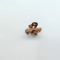 Detail shot of a matte brown bow hair claw clip, perfect for styling short or fringe hair. - Bow / Camel