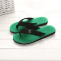 Detail shot of green and black thong sandals with textured insole and strap logo badge. - 40 / Green