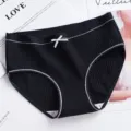 Detail shot of black ribbed cotton women briefs featuring a cute white bow accent. - M / Bottoms / Black