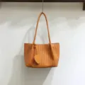 Woven soft leather shoulder bag with chic heart charm, stylish underarm tote for daily wear. - Orange