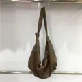 Detail view of the slouchy pleated brown hobo bag, showing soft leather texture and knot strap. - Tan