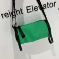 Green nylon cylindrical crossbody bag detail shot, compact barrel shoulder bag style. - 181 Waterproof Green