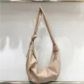 Detailed shot of beige soft leather pleated shoulder bag, slouchy hobo dumpling design. - A Pink