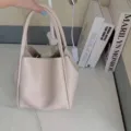 Minimalist beige bucket bag for women, stylish leather handbag with double top handles. - Apricot