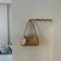 Detail view of trendy beige soft leather shoulder bag with braided strap and cute heart pouch. - Apricot