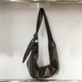 Detailed view of the dark brown soft leather pleated shoulder bag showcasing its unique texture. - Coffee A