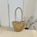 Detailed shot of yellow woven leather bucket bag with top handles, displayed in home scene setting. - Turmeric