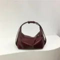 Detailed view of the minimalist burgundy dumpling hobo bag, showing smooth glossy PU leather. - Red