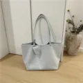 Detailed showcase of soft light blue suede fabric texture and hanging mini charm accessory. - Blue