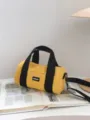 Yellow oxford cloth cylindrical shoulder bag with black handles and crossbody strap. - Yellow