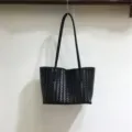 Black woven leather tote bag detail, soft underarm shoulder bag showcasing fine craftsmanship. - Black